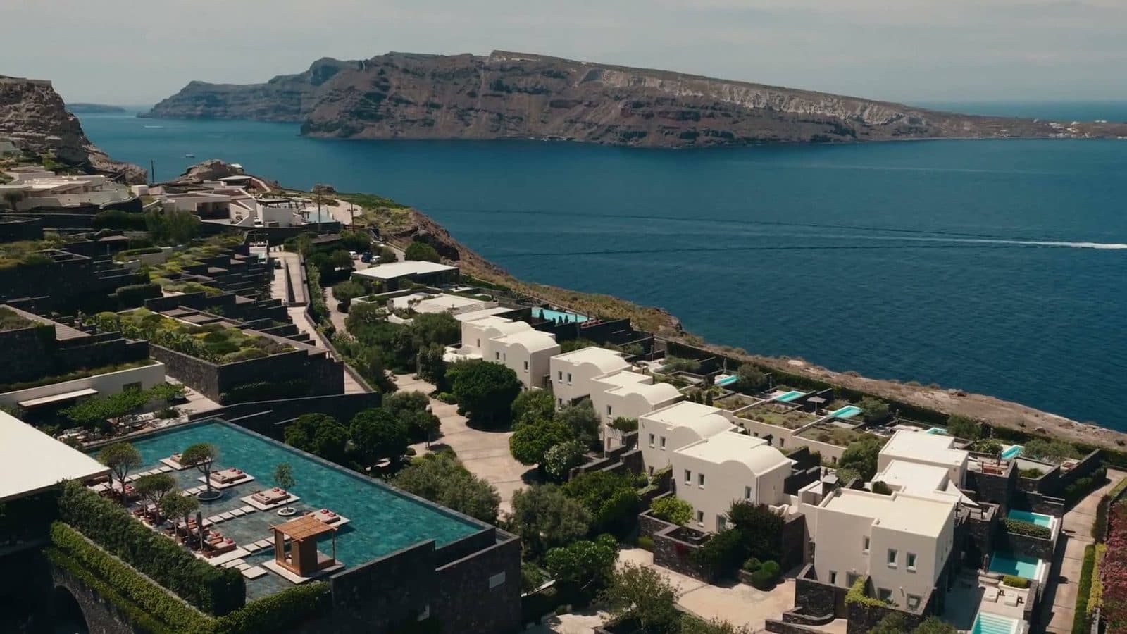Aerial view of Canaves Epitome’s white buildings, pools and gardens above the sea