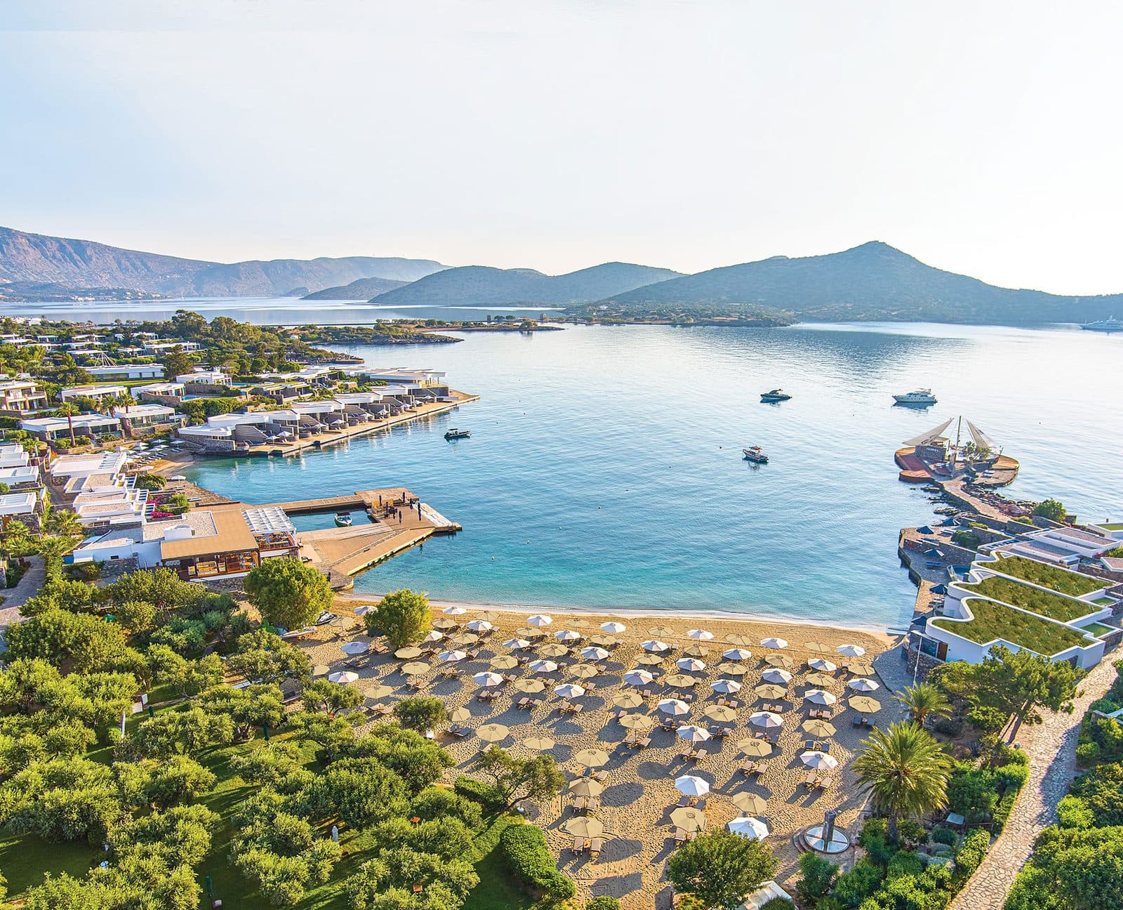 Aerial view of Elounda Beach’s beach and seafront buildings in the bay