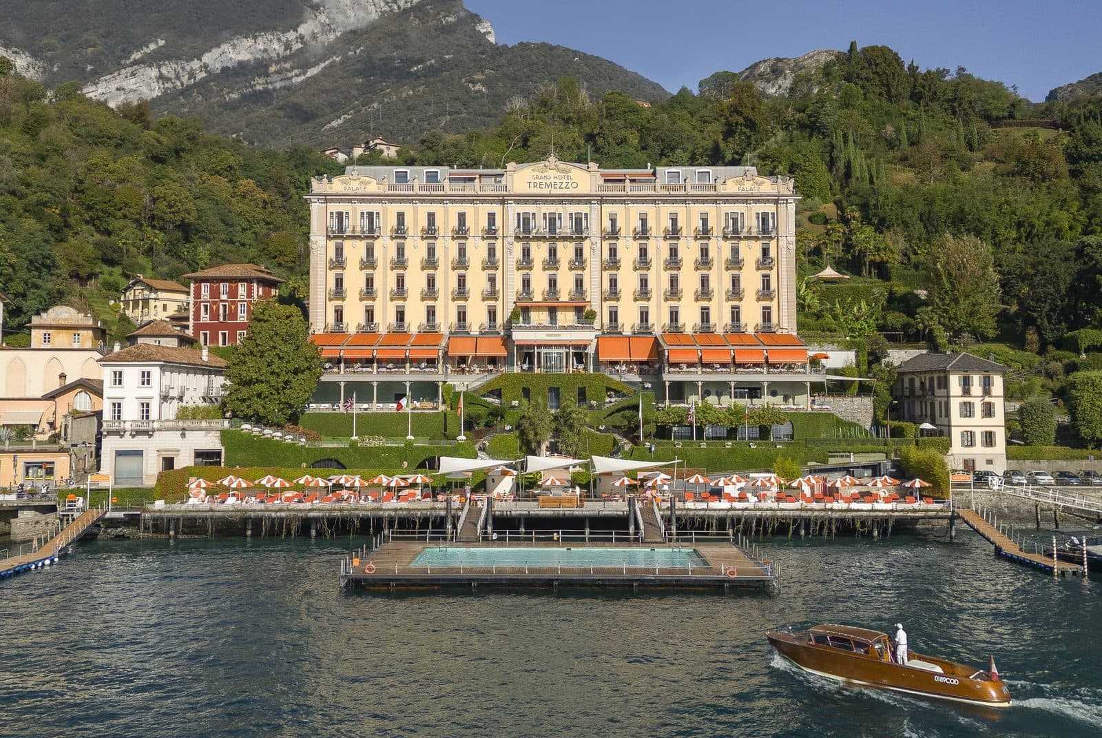 Grand Hotel Tremezzo на берегу Комо, плавучий бассейн перед фасадом и катер у причала
