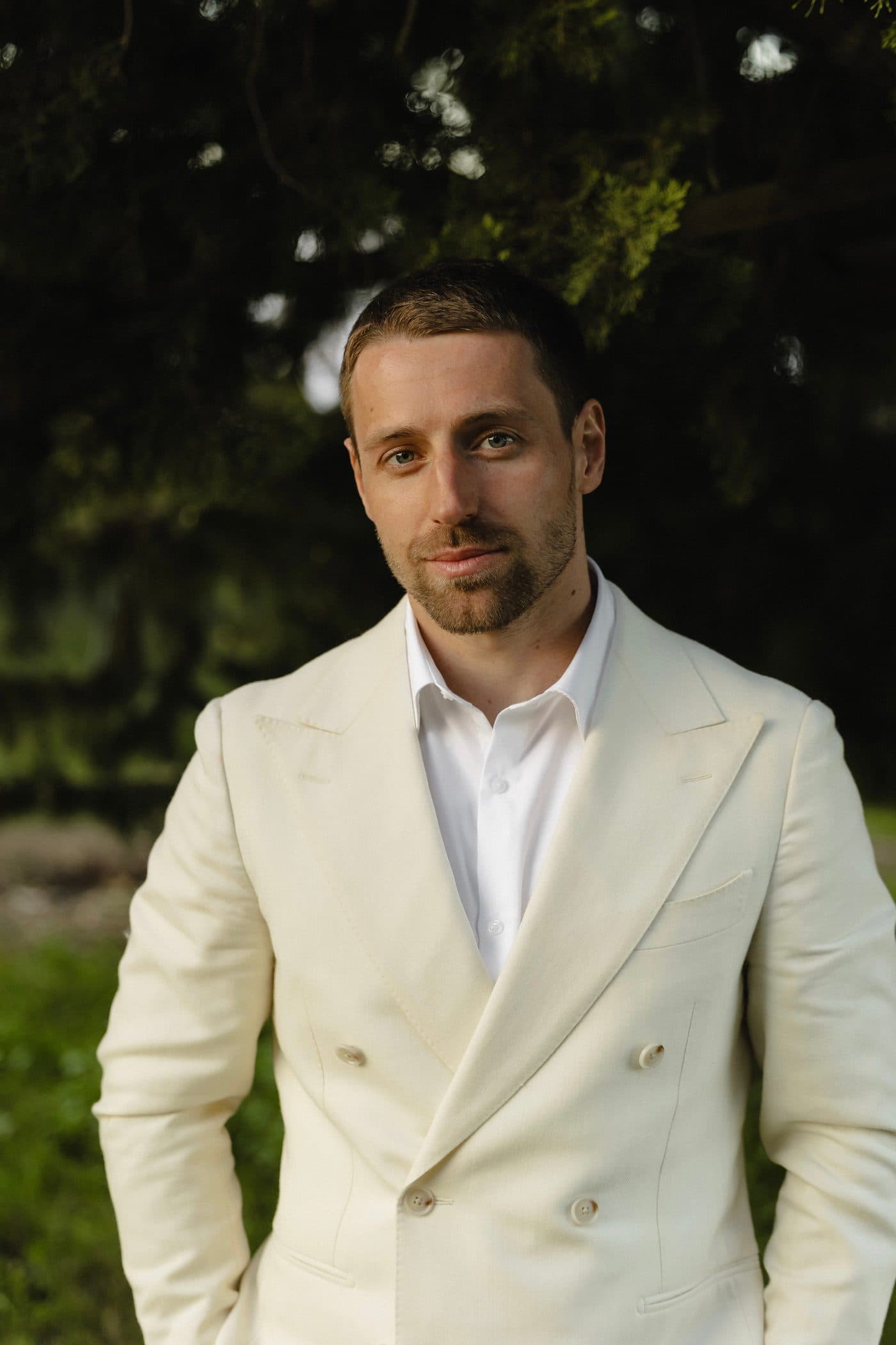 Lev Solenov, founder of R-U Travel, in a pale double-breasted jacket against greenery